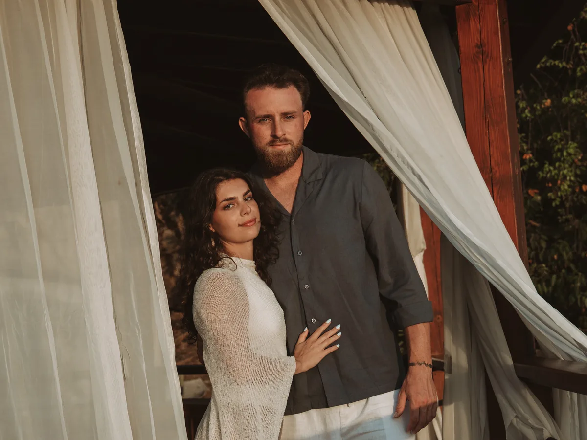 Jake and his girlfriend standing together on a terrace at sunset